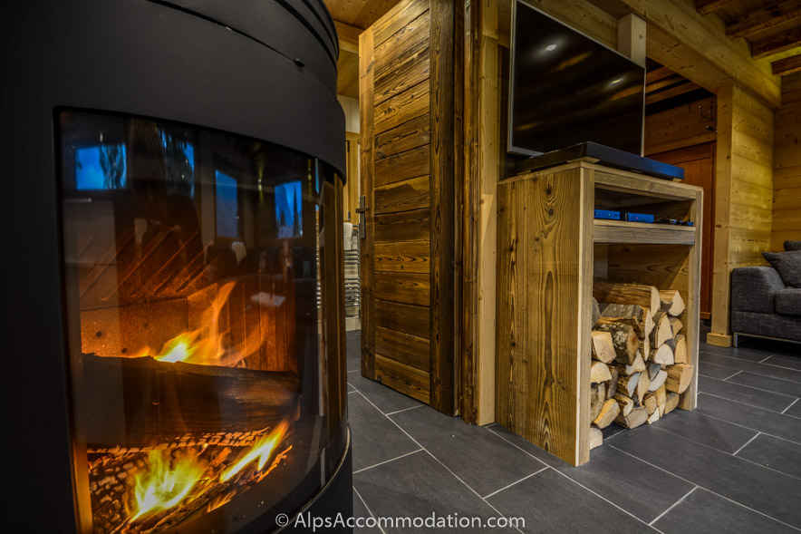 Chalet Toubkal Samoëns - Cosy log burner and beautiful detail of the handcrafted door and log storage