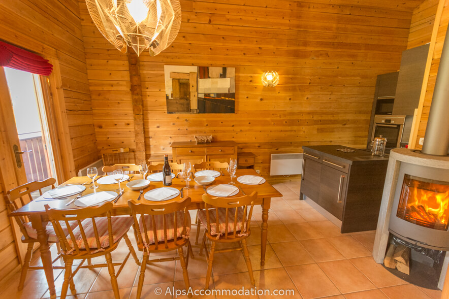 Chalet Booboo Morillon - Large wood dining table set between the cosy log fire and glass doors giving stunning views over the valley