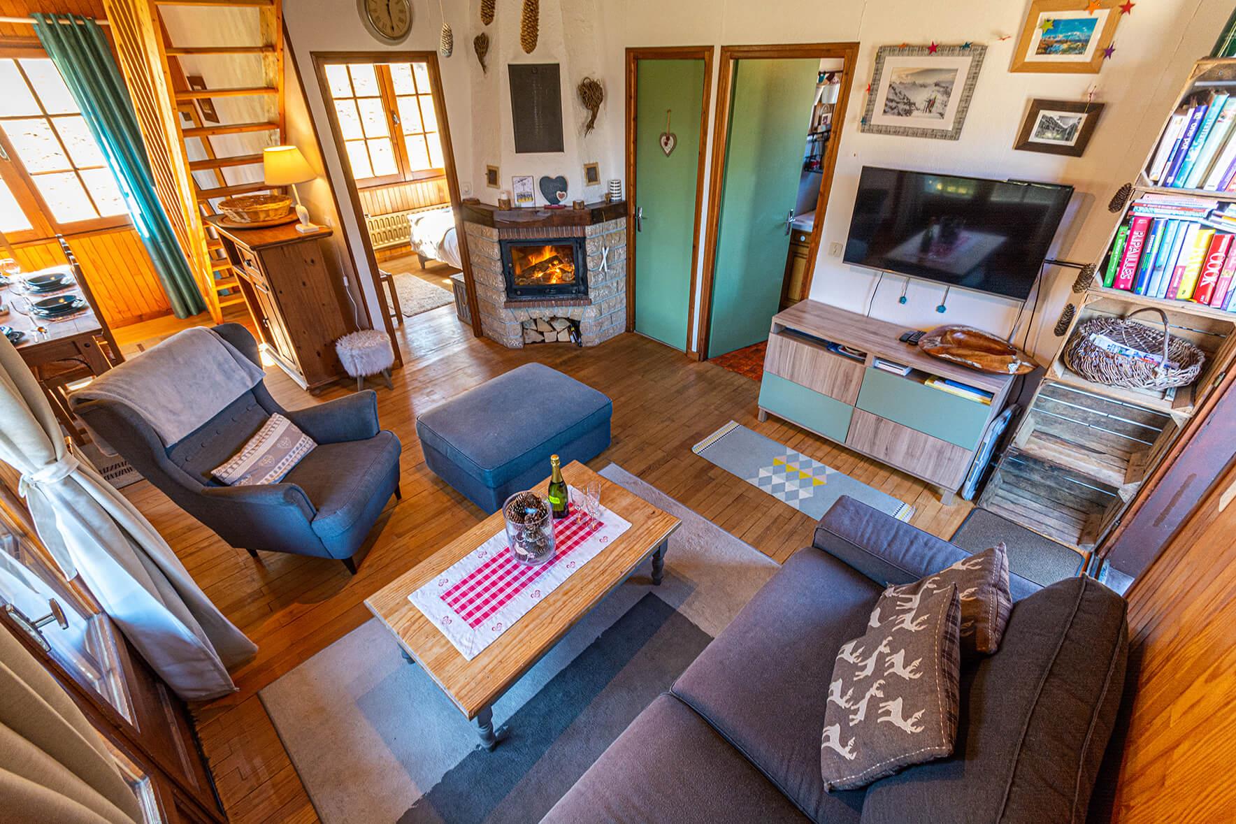 Chalet Le Gerbera La Rivière Enverse - The living area features comfortably seating and a log fire