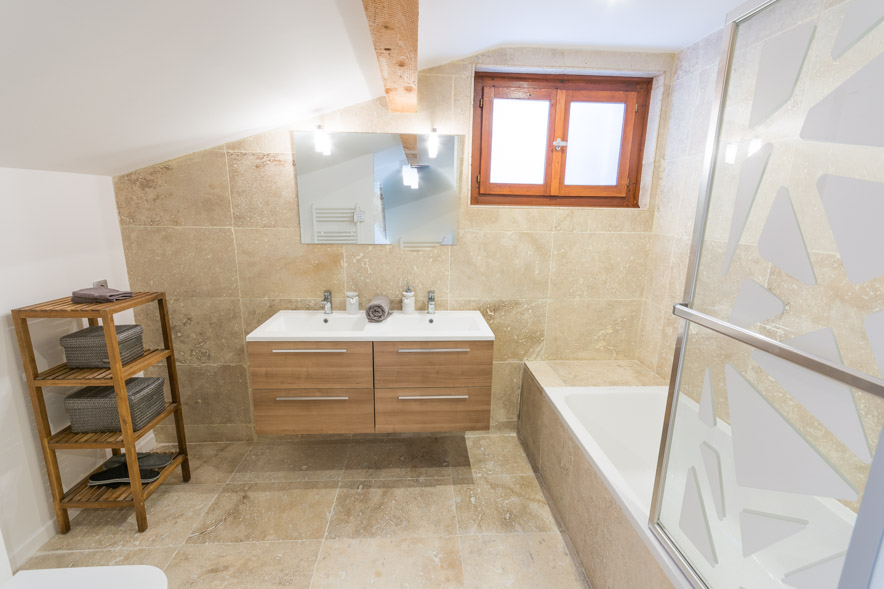 Chalet Falconnières Samoëns - Ensuite bathroom featuring a large bath with shower and quality stone tiles